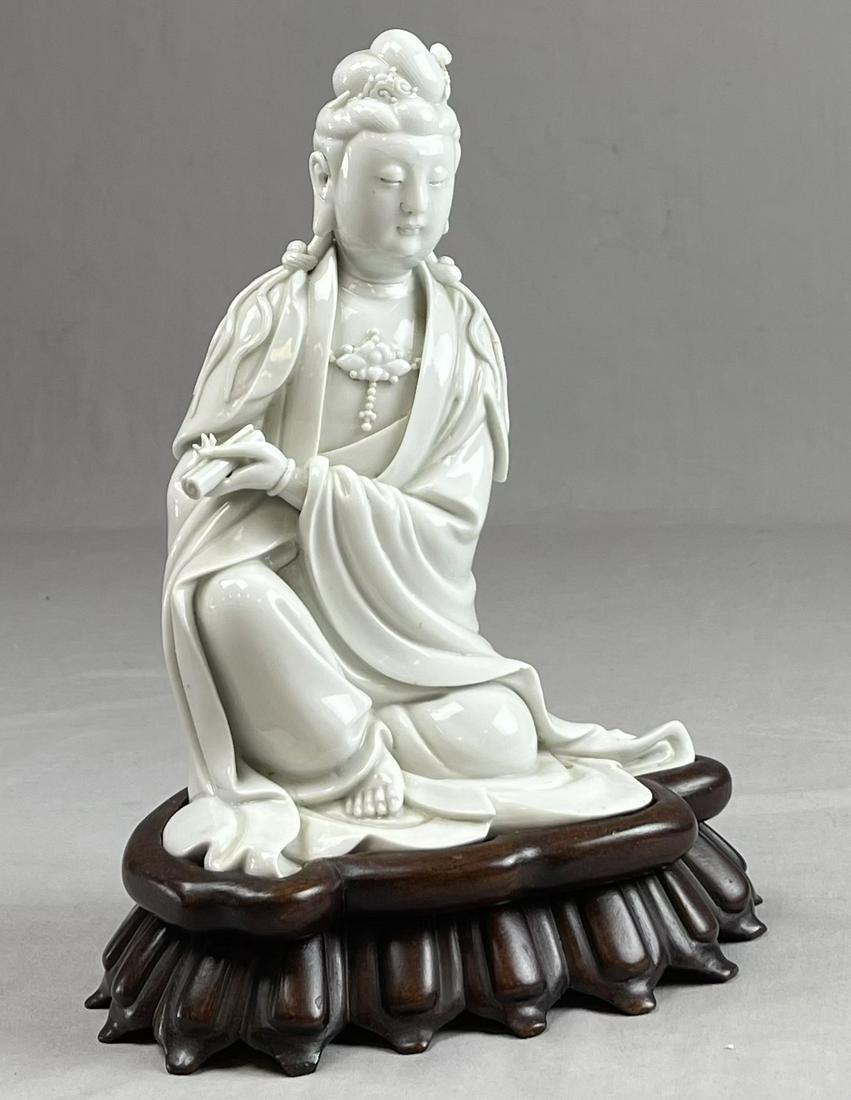 Blanc De Chine Figure of Guanyin with Scroll: Figure of Guanyin of the Ming dynasty on a wooden base. The height of the figure is 9". Total height including the base is 11"
