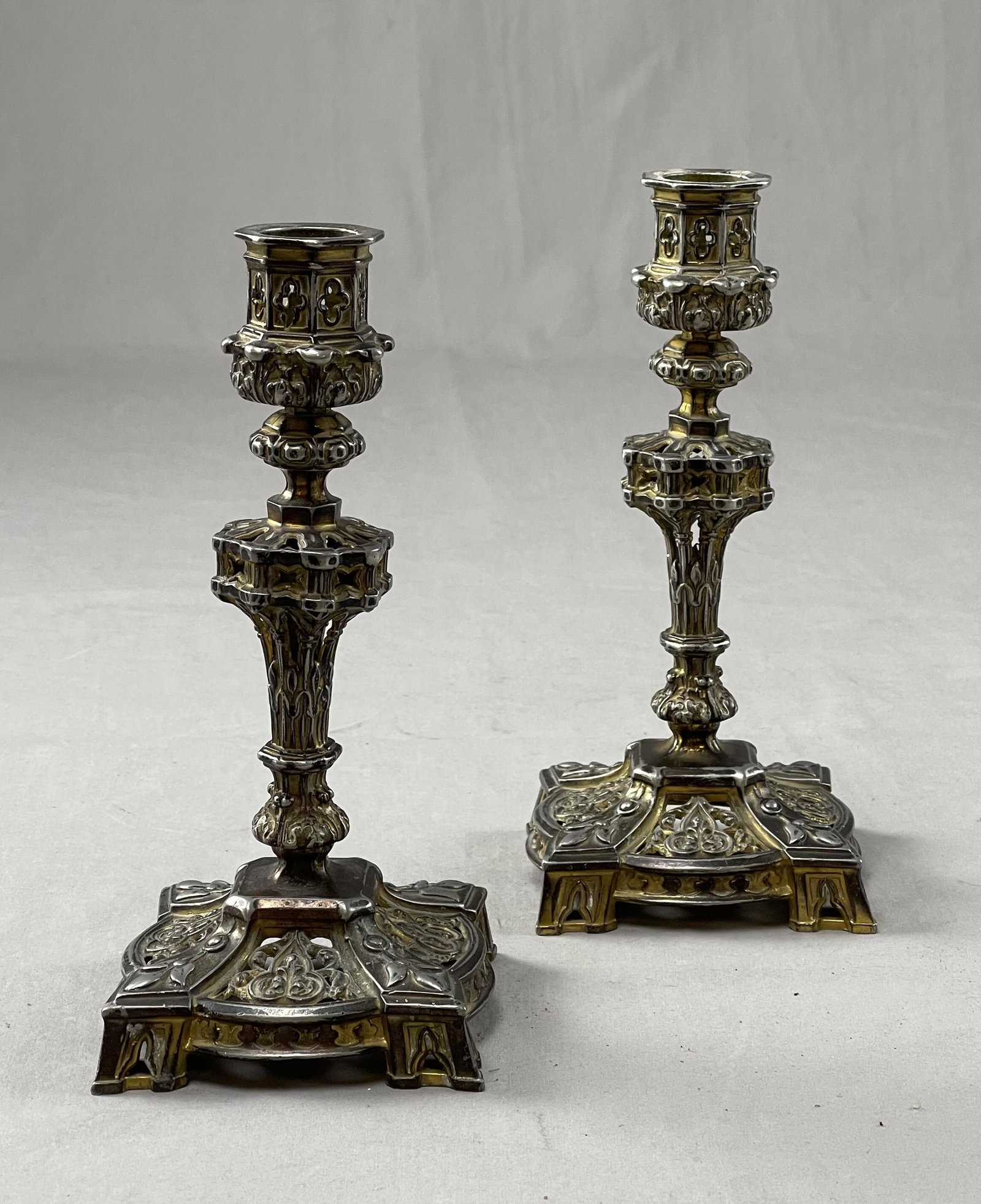Pair French Gothic Revival Spelter Candle Sticks: Worn gold and bronze finish. Impressed number (E1353) on bottom. Measure 8" in height.