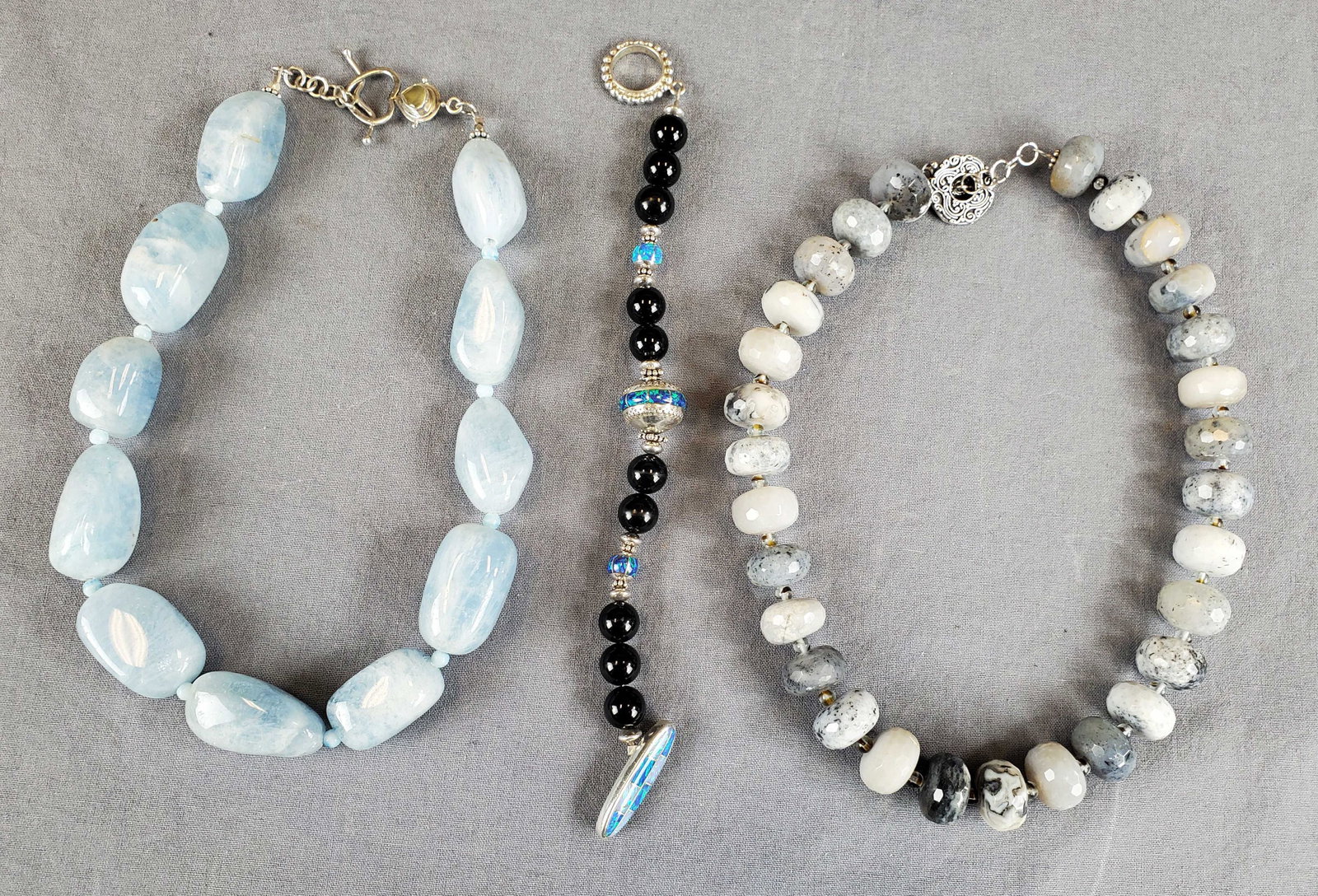 Lot Of 3 Natural Stones And Sterling Jewelry: (1) 16" Amazonite polished stone and sterling clasps ( no marks) (1) gray natural stones 16" necklace sterling clasps ( no marks) and (1) Onyx and Opal of Scottsdale bracelet. 925 clasps marked 6 1/2"