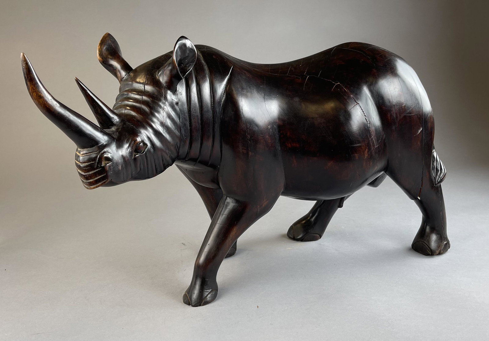 Large African Woodcarving of a Rhinoceros: Large hand carved rhinoceros , quite heavy, appears to be ebony. Length 27" Height 15-3/4" Shipping: Local pick-up or 3rd party shipping only for this lot. Please see the Shipping Policy for informati