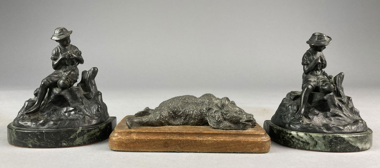 Bronze Bear and Fishermen Bookends: Bronze boy fishing bookends with marble base. Marked Austria. Bookends are 5 1/2 inches tall and 4 3/4 inches wide. Bronze bear on wood platform with green felt bottom. 2 1/2 inches tall and 7 inches