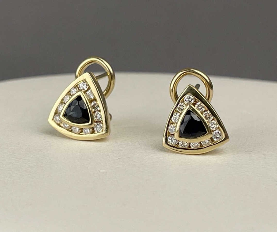 14KYG Sapphire & Diamond Omega Back Earrings: 14K yellow gold pierced earrings with appx .25ct trillion cut sapphires and appx .01ct diamonds.Appx. 1/2 carat total weight SapphiresAppx. 1/2 carat total weight Diamonds TOTAL WEIGHT: 5.02 grams SHI