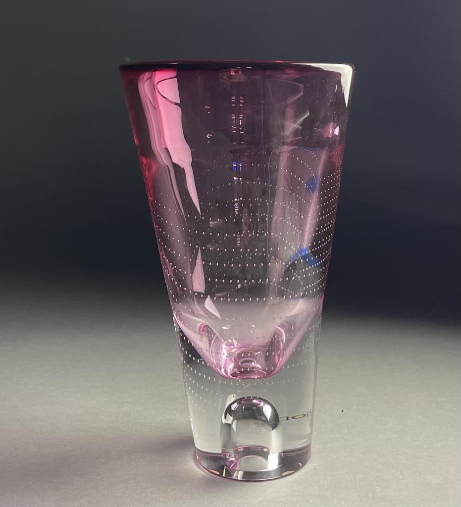 Kosta Boda Goran Warff Glass Bubble Vase 9-1/2": Kosta Boda pink trumpet art glass bubble vase. Measures 9-1/2" and 5-5/8" at the widest point. CONDITION: Retains original Kosta Boda tag. SHIPPING: In-House Shipping Available for this lot. Please re
