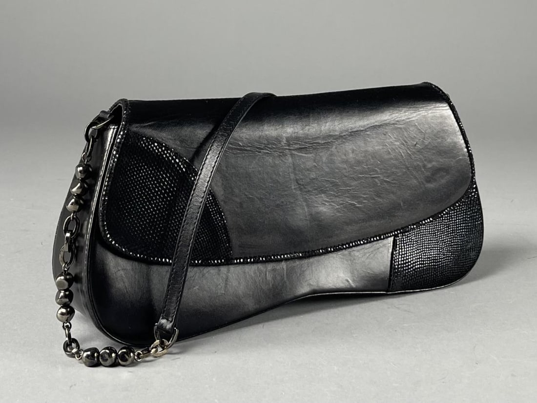 Vintage Stuart Weitzman Black Leather Handbag: The "Cheeky" bag by Stuart Weitzman in black leather with textured suede trio and graphite colored metal accents. Width 12-1/4", depth 1-5/8", height 5-1/2". Box and dust bag included. CONDITION: Very