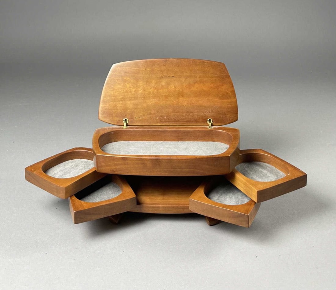 Kellam's Hand Crafted Cherry Jewelry Box II: Artist made modernist cherry jewelry box by Thom and Sue Kellam circa late 20th century. Velvet lined compartments pivot out at each side. Signed on underside. 10" x 5" x 5-1/4" tall. SHIPPING: In-Hou