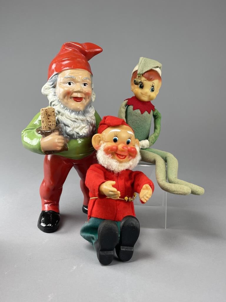 3 Holiday Elf and Gnome Figures: The elves in rubber and fabric, the gnome in painted terracotta. The tallest measure 14". CONDITION: Some fading on the fabric. SHIPPING: In-House Shipping Available for this lot. Please read our Ship