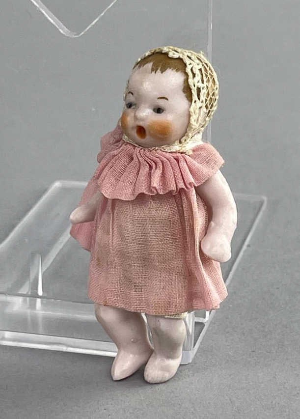 Made in Germany Bisque Baby Doll in Pink Dress: Marked Germany along back, shoulder and hips are jointedAppx 2.5'' SHIPPING: In-House shipping available. Please read our Shipping Policies prior to bidding.