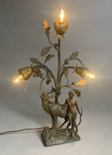 Art Nouveau Figural Lamp Diana the Huntress: Three light figural spelter lamp depicting Diana with an elk beneath an oak tree. It is in a patinated bronze toned finish. Height 18-1/2".