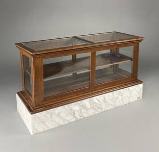 Salesman's Sample Store Display Case: Miniature wood and glass counter type display case on a marble base, possibly a salesman's sample piece. Height 14-1/2", width 26", depth 9-3/4". There is not a door opening though the top glass panes