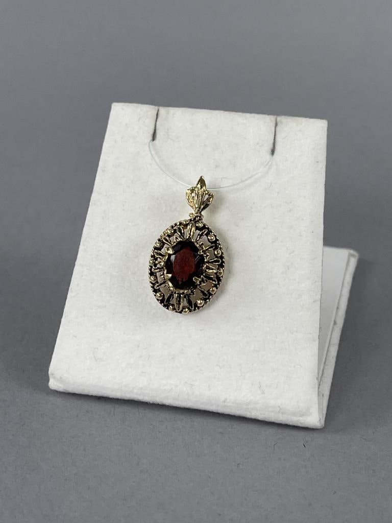 14K Yellow Gold Filigree and Garnet Pendant: 2.32 grams total weight. 1/2'' across.