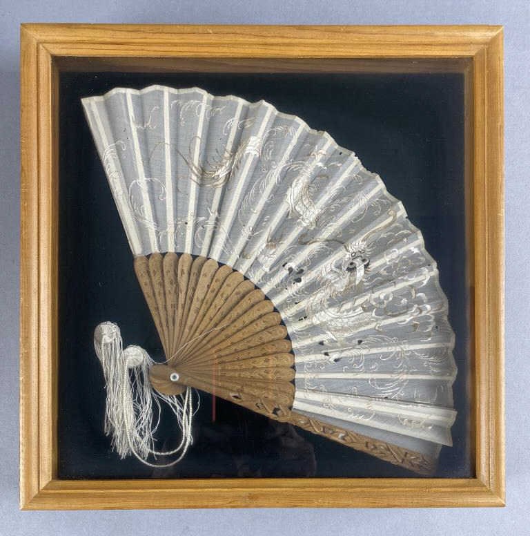 Antique Chinese Dragon Embroidered Fan: Late 19th century Chinese fan mounted in a shadow box. A note on the reverse that it was purchased at a Marshall Fields International Fair. Framed size 12-3/4" x 12-3/4".