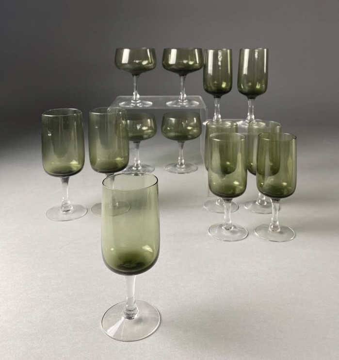 Fostoria "Glamour" Green Midcentury Stemware: 13 pieces of fone midcentury modern stemware from Fostoria, the "Glamour pattern, introduced in 1968, in green. Includes (7) 6" tulip wine glasses, (2) 7-1/8" water goblets and (4) coupe champagne/tal
