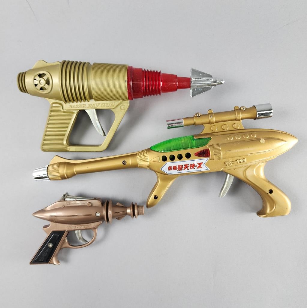 Friction Razer Ray Gun, ZEE International Ray Gun: Gold colored plastic friction Razer Ray Gun marked CH in circle.ZEE International Ray Gun cap gun, Made in Hong Kong.14'' x 6'' gold plastic friction space gun.
