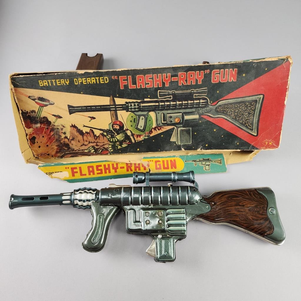 Battery Operated Flashy-Ray Gun in Original Box: T.N Made in Japan tin litho space gun.Box is rough. Measures 19.5" X 6.5" X 1.5".