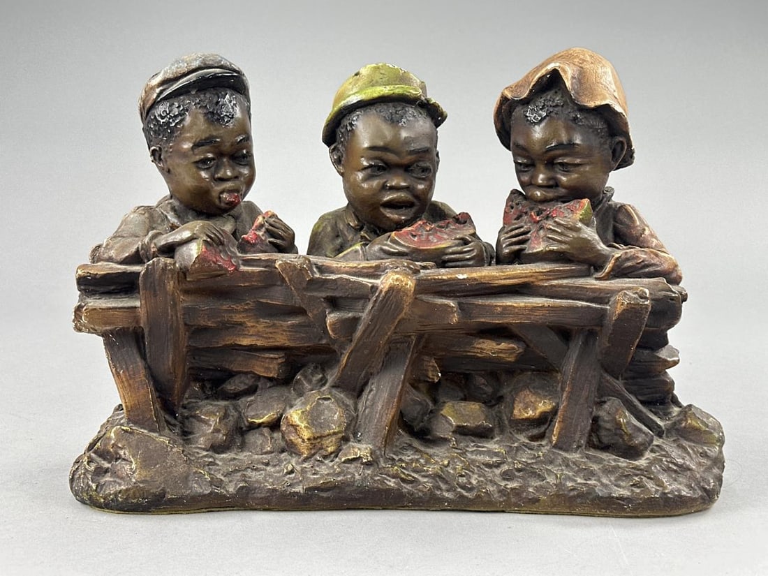 Black Americana Chalkware Figure Group: Vintage chalk ware of 3 boys eating watermelon - some chipping on top of green hat and on fence pieces - measures 15" x 6" x 12".