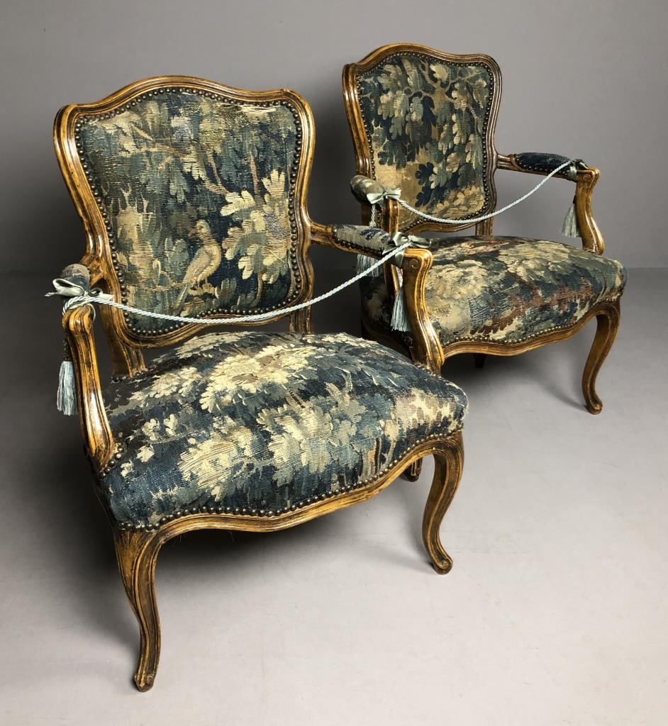 Pair of French Louis XV Fauteuils Armchairs: Pair of French Louis XV style Fauteuils, or open armchairs, upholstered with fragments of antique verdure tapestries, possibly 17th or 18th Century Franco-Flemish, each chair is approximately 24-3/4"