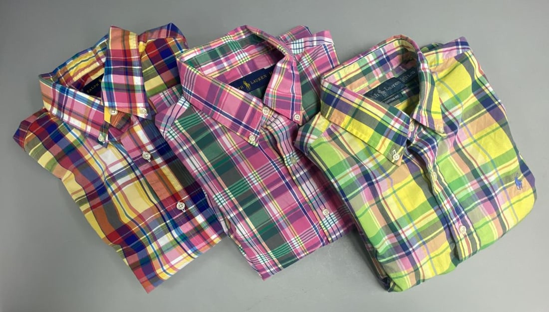 3 Vintage Polo Ralph Lauren Madras Plaid Shirts: Three men's cotton madras plaid shirts from Polo Ralph Lauren. One of the long sleeve shirts and the short sleeved shirt are size large and one of the long sleeved sleeve shirts is size medium.