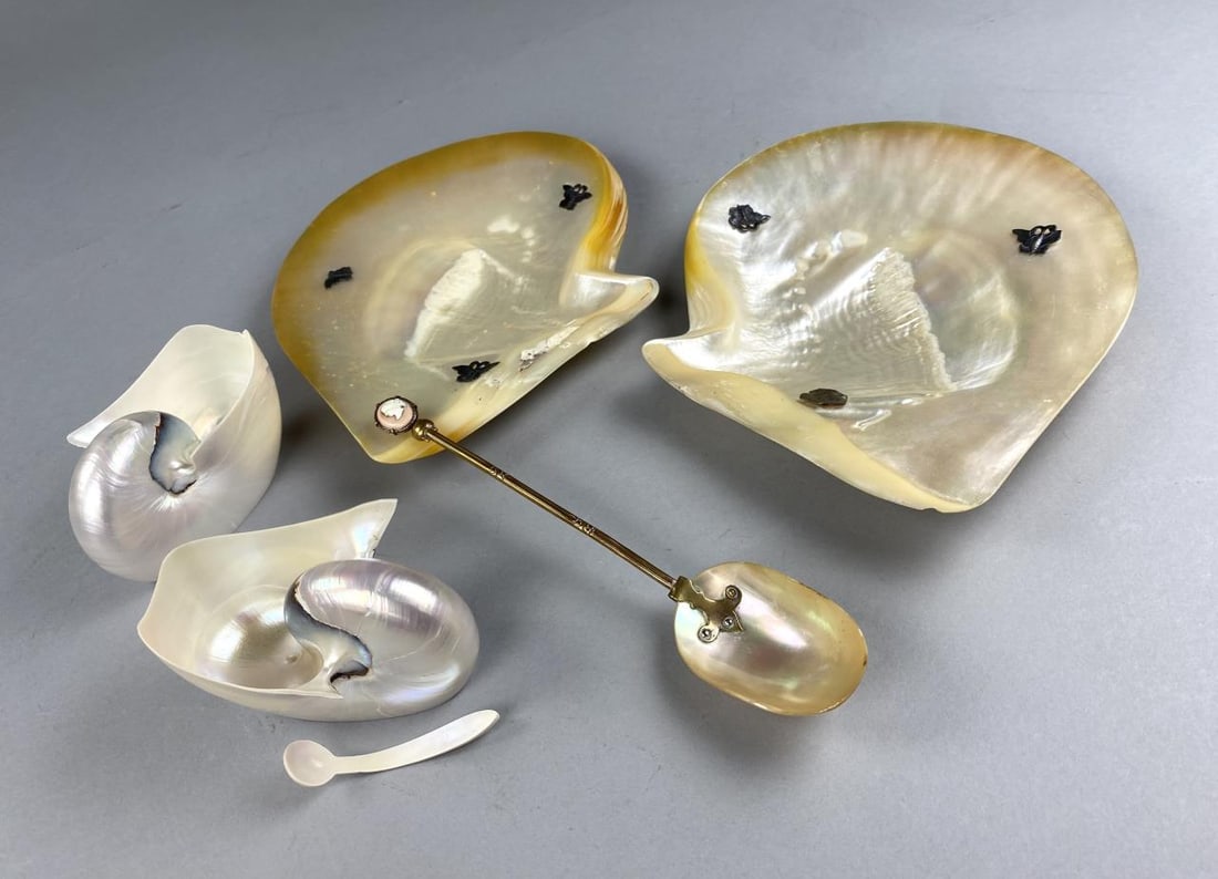 Shell Spoon, M.O.P. & Silver, and Nautilus Dishes: Mother of pearl shell and brass 9" serving spoon with cameo handle, two m.o.p. shell and silver 10" dishes, feet and butterfly attachments are sterling silver, and two nautilus shell caviar serving di