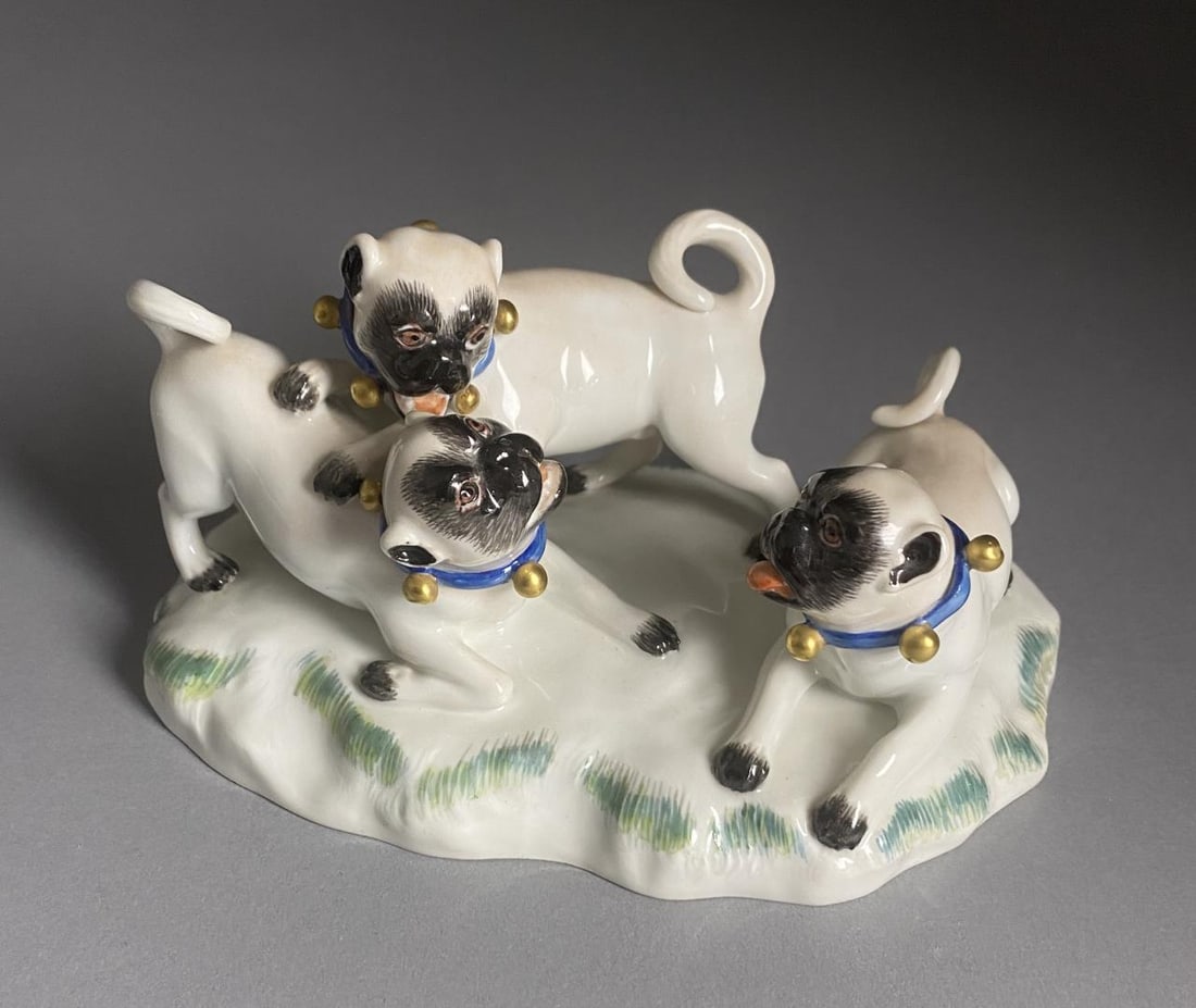 Meissen Porcelain Figure Group Pug Dogs Playing: Meissen porcelain figure group of three pug dogs, all wearing blue collars with gold painted bells, marked on underside with the underglaze blue crossed swords mark, impressed "78836", and possibly "1
