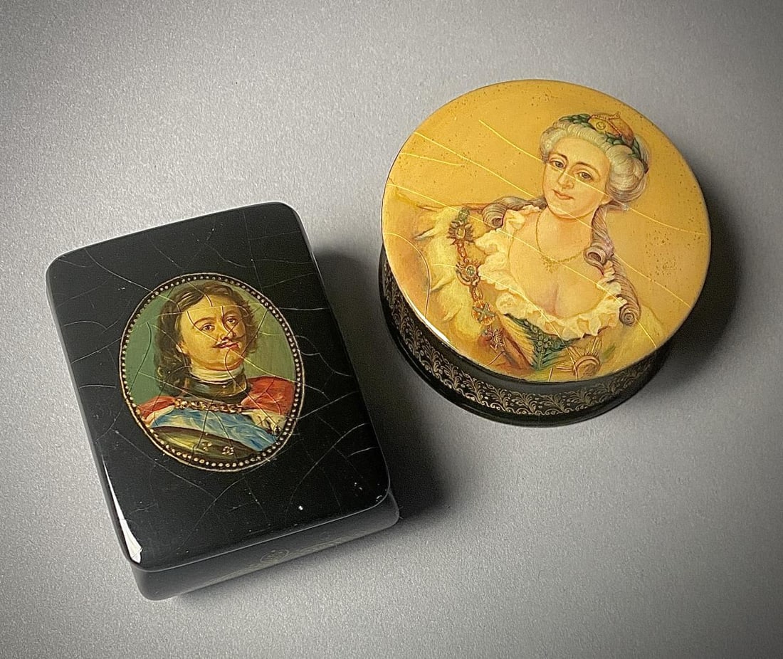 2 Russian Lacquer Boxes Peter I & Catherine II: Two Russian lidded, black lacquer, hand painted boxes with red interiors, one depicting Peter I, also known as Peter the Great (approximately 2-5/8" L x 2" W x 1-1/8" H), and the other depicting his w