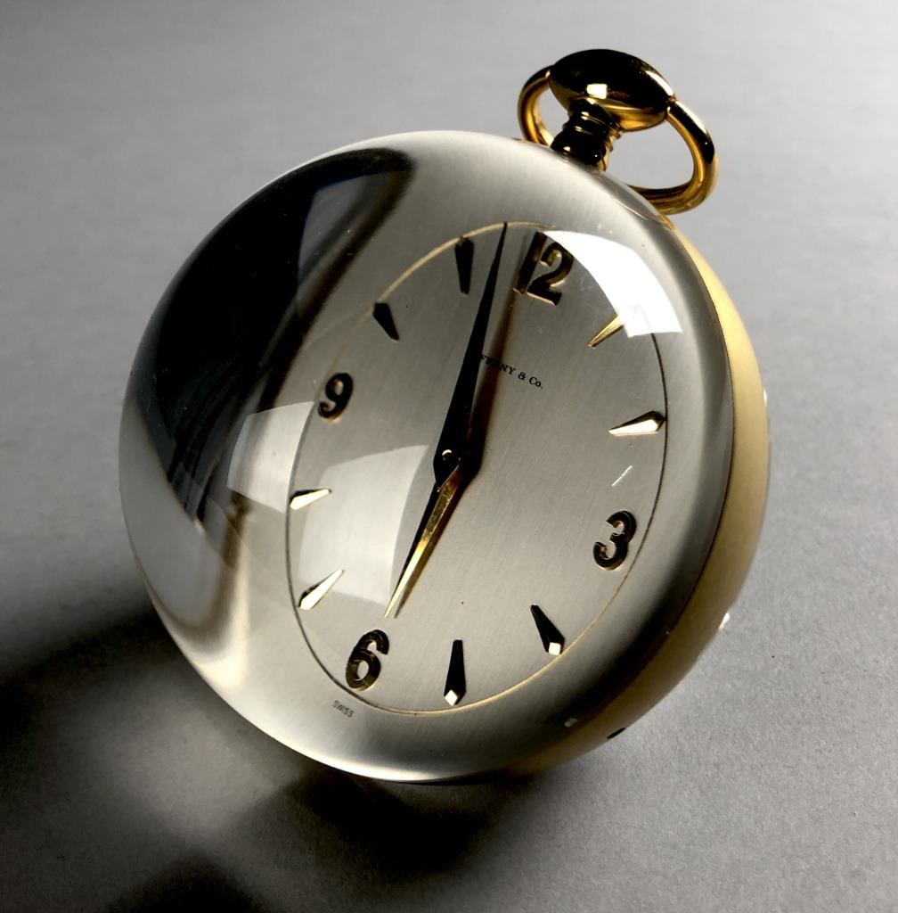 Tiffany & Co. Swiss Lucite Ball Paperweight Clock: Tiffany & Co. Swiss clear acrylic sphere globe ball and gold-tone metal table top paperweight desk clock, circa 1960s, marked on face, "Tiffany & Co. Swiss," marked on back, " Switzerland M IMHOF Fift