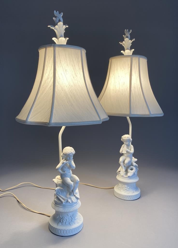 Pair of Continental Bisque Porcelain Boudoir Lamps: Pair of Continental bisque porcelain boudoir or table lamps with Classical putti or cherubs playing flutes, circa mid 20th Century, with cut corner square bell shaped shades, each 29-3/4" H (with fini