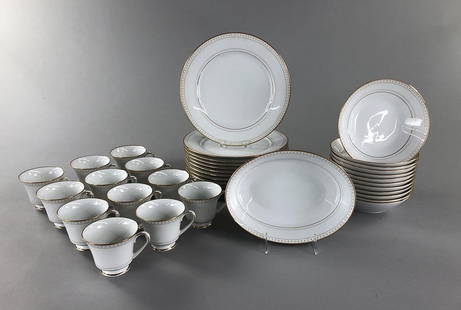 Service for 12 Noritake Barrington 1969: Noritake china, or dinnerware, in the Barrington pattern (#2030), which was produced between 1969 and 1980, and features gold crosses and scrolls on a white background. This service for 12 includes: (