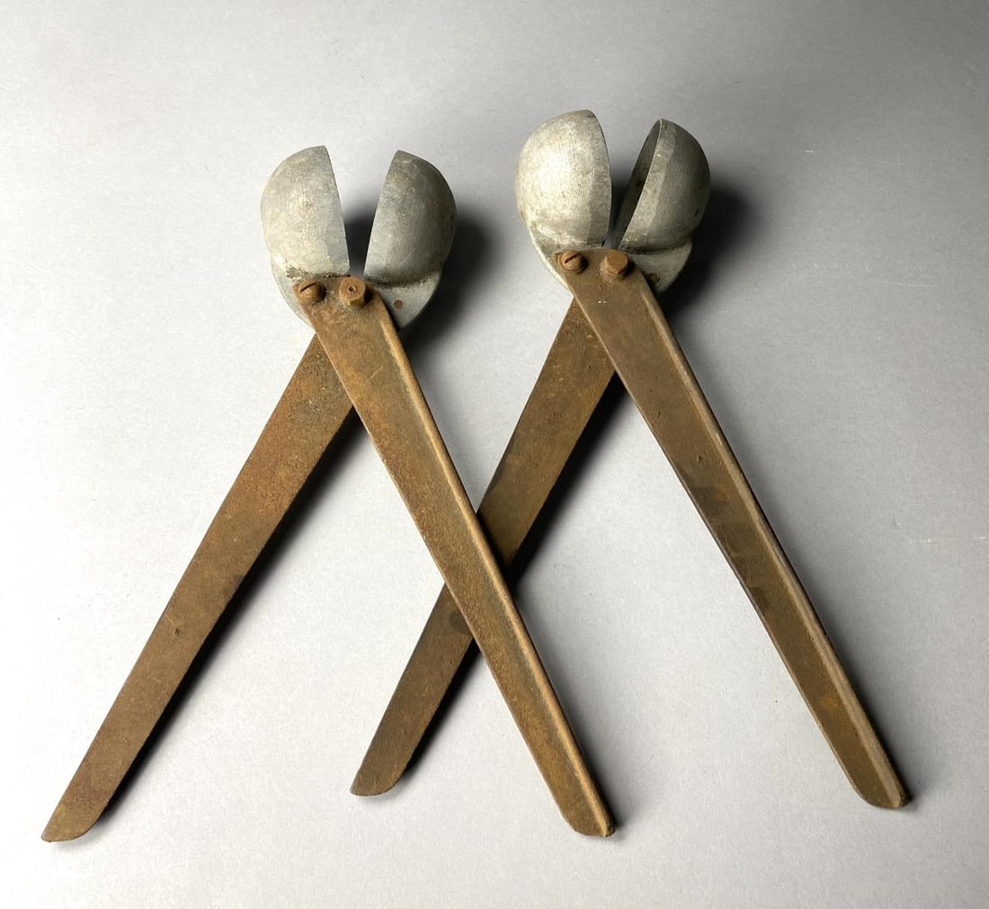 Two Metal Hinged 3 Inch Popcorn Ball Makers: Two metal hinged 3" popcorn ball makers, 14-3/4" long. Provenance: Schiappacasse's Candy Kitchen, Flint, Michigan (1886-1971).