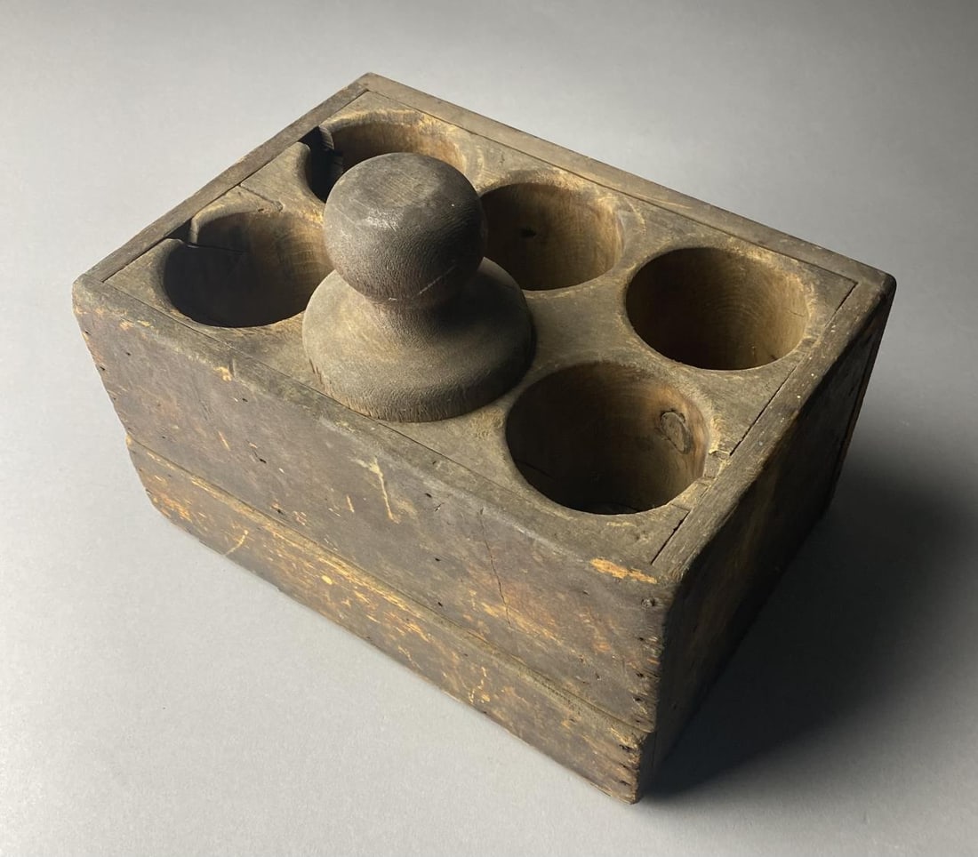 Sugar, Candy, Popcorn Baller, Wooden Hinged Box: Wood hinged box with 6 cylindrical holes rounded at bottom with a rounded pestle for packing popcorn, sugar, or candy into balls.