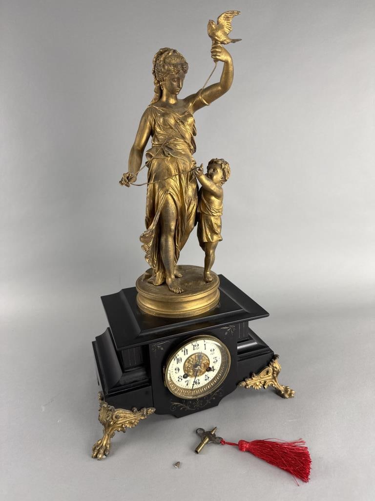 L. Marti Peiffer Figural Mantel Clock: Peiffer is signed on the base of the statue. Clock comes with pendulum and key. Functions, but may need to be cleaned, serviced or repaired.Appx. 23'' H x 12'' L x 7 1/2'' W