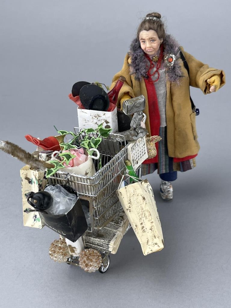 Bag Lady And Cart By Delores Cole, 1992: One of a Kind from a prolific doll artist from Indiana. She is 5 1/2" with 2 coats, a sweater, slacks and gloves to keep her warm. Dirty tennies, lots of jewelry and a handbag with dice on it. The ove