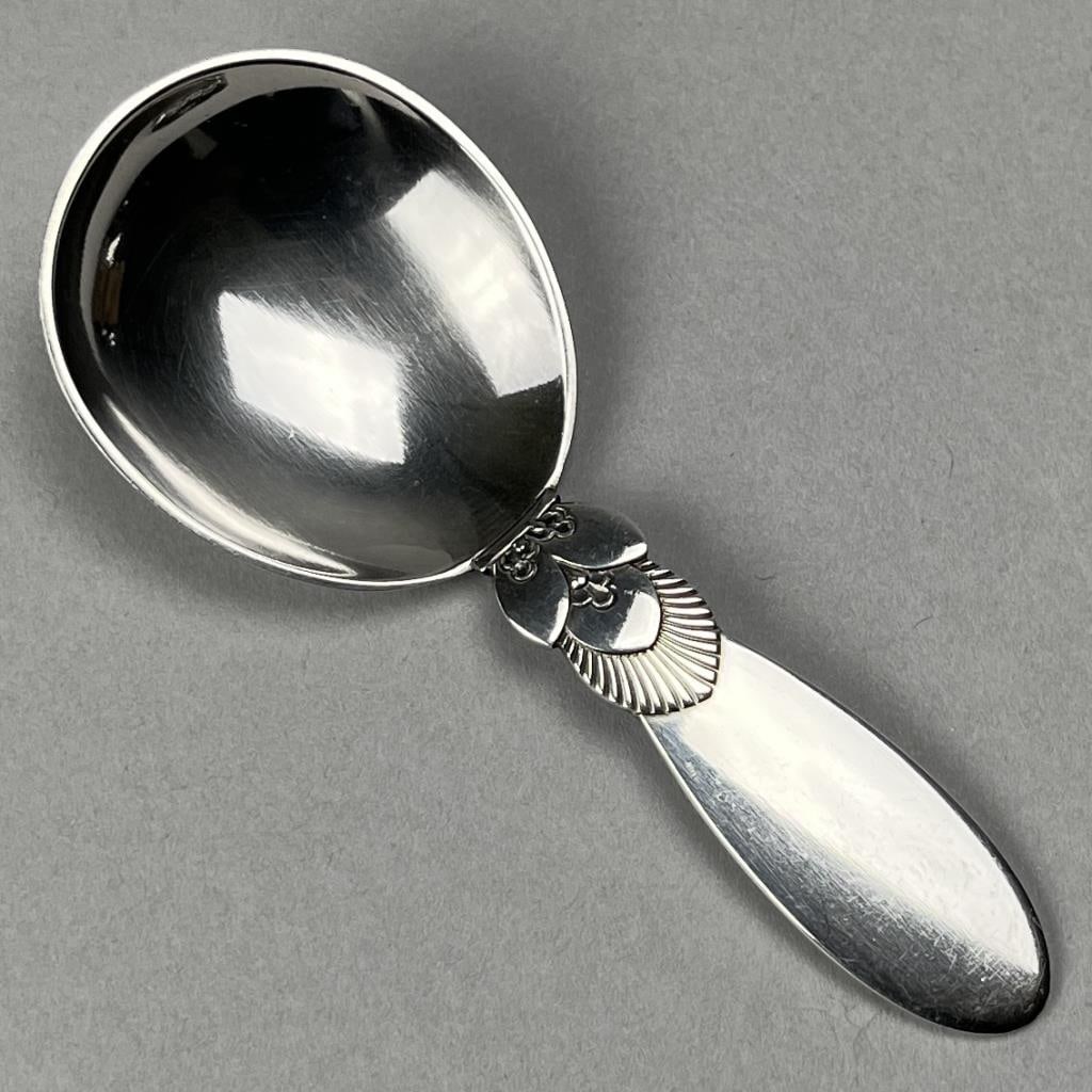 Georg Jensen Cactus Sterling Sugar Spoon: Georg Jensen sterling silver sugar spoon, in the "Cactus" pattern, designed by Gundorph Albertus (Danish, 1887 - 1969) and introduced in 1930, 3-7/8" L, 26 grams.
