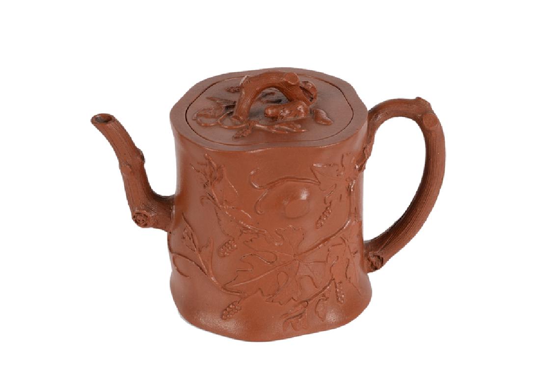 A Yixing teapot, decorated with acorn branches. Knob in: A Yixing teapot, decorated with acorn branches. Knob in the shape of a branch with squirrel. China, 18th century. H. 11 cm.