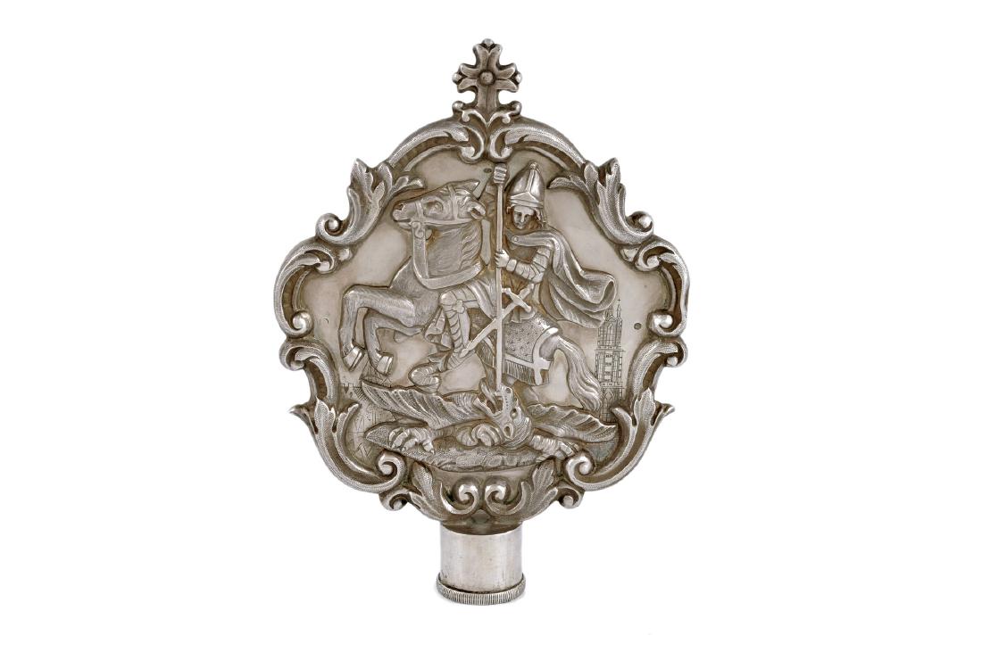 Een zilveren bekroning van een staf, verm. van een: Een zilveren bekroning van een staf, verm. van een bisschopsstaf. Aan de ene kant een afbeelding van Maria met kind, aan de andere kant sint Joris en de draak. Mt. Lieuwe Pronk, o.a. Middelburg en Den