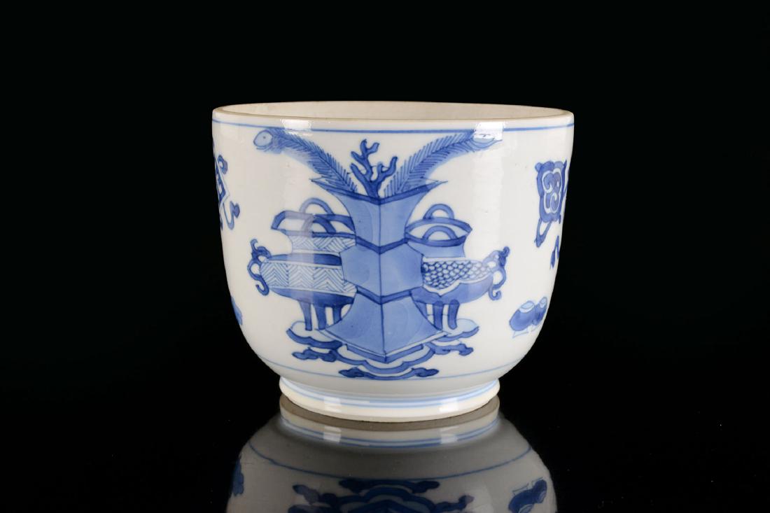 A blue and white porcelain beaker with a decor of: A blue and white porcelain beaker with a decor of antiquiteiten. China, Kangxi. Lid missing. H. 8,5 cm. Diam. 10,5 cm.