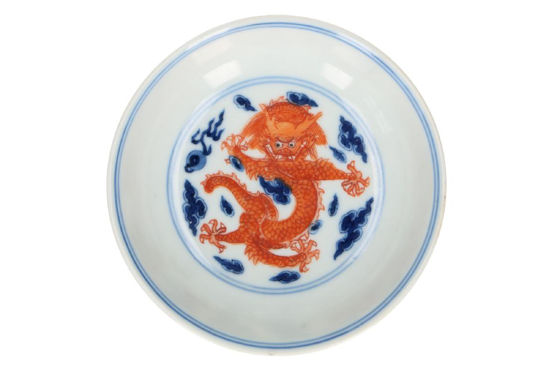 A polychrome porcelain saucer, decorated with three: A polychrome porcelain saucer, decorated with three five-clawed dragons. Marked with seal mark Jiaqing. China, Jiaqing. Diam. 10,5 cm.