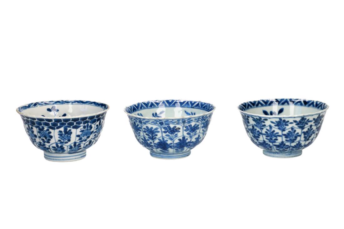 Lot of two blue and white porcelain cups, decorated: Lot of two blue and white porcelain cups, decorated with flowers and in the centre long Elizas. Unmarked. Added a blue and white porcelain cup with floral decor. Marked with censer. China, Kangxi. H. 