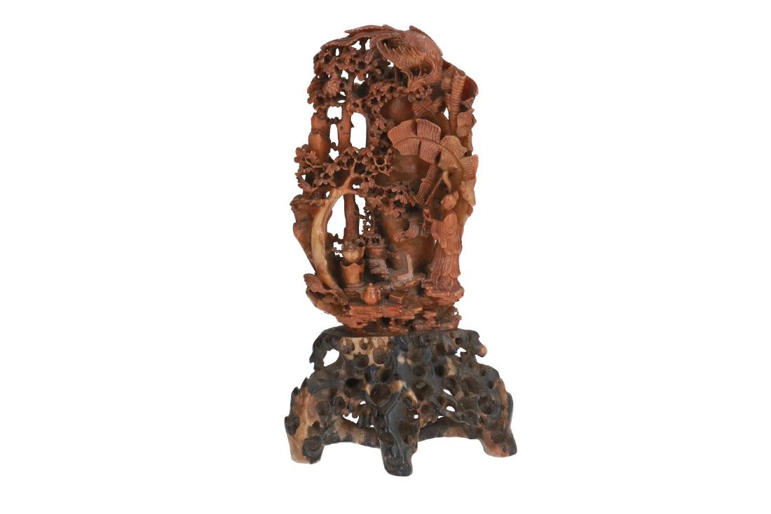 A carved soapstone sculpture of a figure standing under (1 of 6)