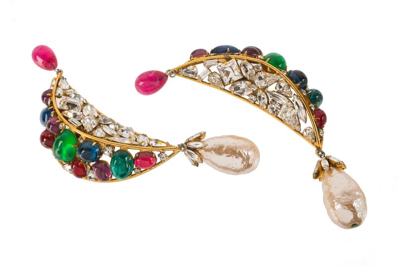 An Iradj Moini (attributed to) goldtone pair of: An Iradj Moini (attributed to) goldtone pair of earclips, set with red, green and blue stones, rhinestones and faux pearls. Unsigned. L. 12,5 cm.