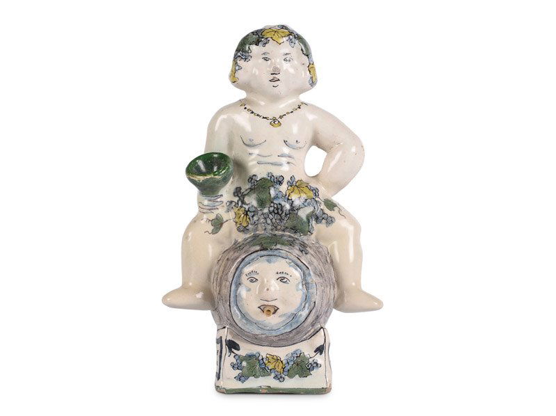 Polychroom 'FaÃ¯ence de Bruxelles' aardewerk sculptuur: Polychroom 'Faïence de Bruxelles' aardewerk sculptuur van de Romeinse god Bacchus zittend op een wijnvat met in de hand een bokaal. Het vat met masker. Brussel, midden 18e eeuw. H. 18 cm.