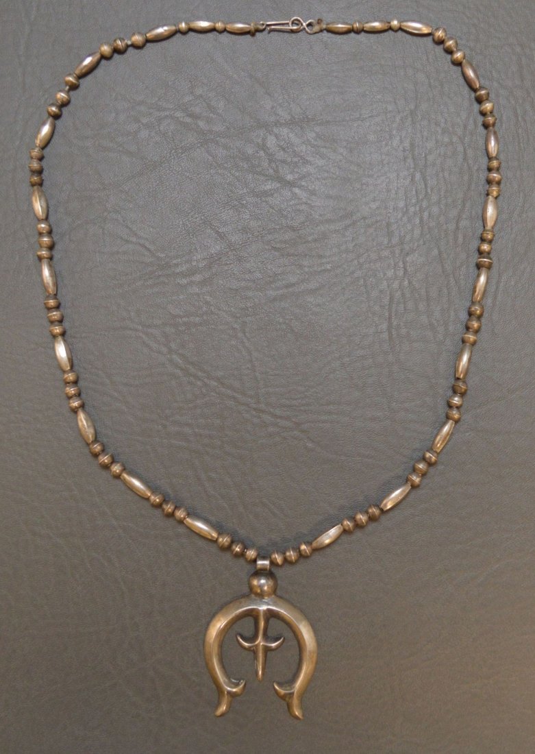 NAVAJO SILVER NECKLACE AND PENDANT: 1960-70's single strand of sterling silver beads 26" long with sand cast traditional designed naja 1.5" x 2.5". Approximate weight: 1.5 oz Shipping for this lot: $10.00 (CONTINENTAL UNITED STATES ONLY