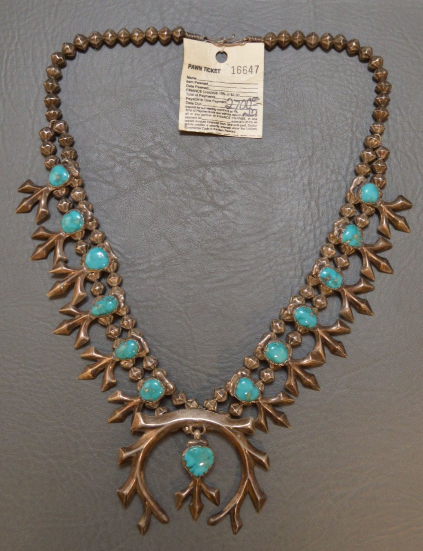 ZUNI SILVER SAND CAST SQUASH BLOSSOM NECKLACE: 1960's sterling silver beads with sterling sand cast and turuoise blossoms, 23" long. Matching sand cast naja with turquoise 3" x 3". Has "dead pawn" ticket Shipping for this lot: $10.00 (CONTINENTAL 