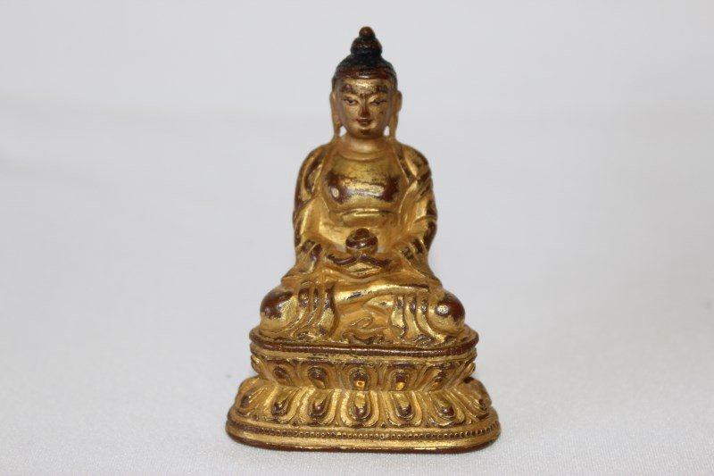 Gilt Bronze Figure of Bhaisajyaguru: depicted seated on a double lotus throne and supporting a medicine jar with both hands, h 7cm Estimate: 350 - 650