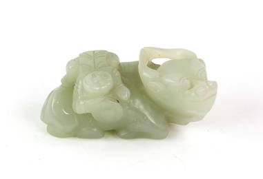 A small green jade carved as a boy climbing onto a