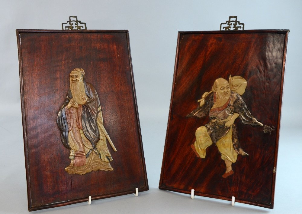 Two Chinese hardwood wall panels each decorated with: Two Chinese hardwood wall panels each decorated with Daoist immortals in coloured soapstone, 12½ x 8½in. (30 x 20cm)