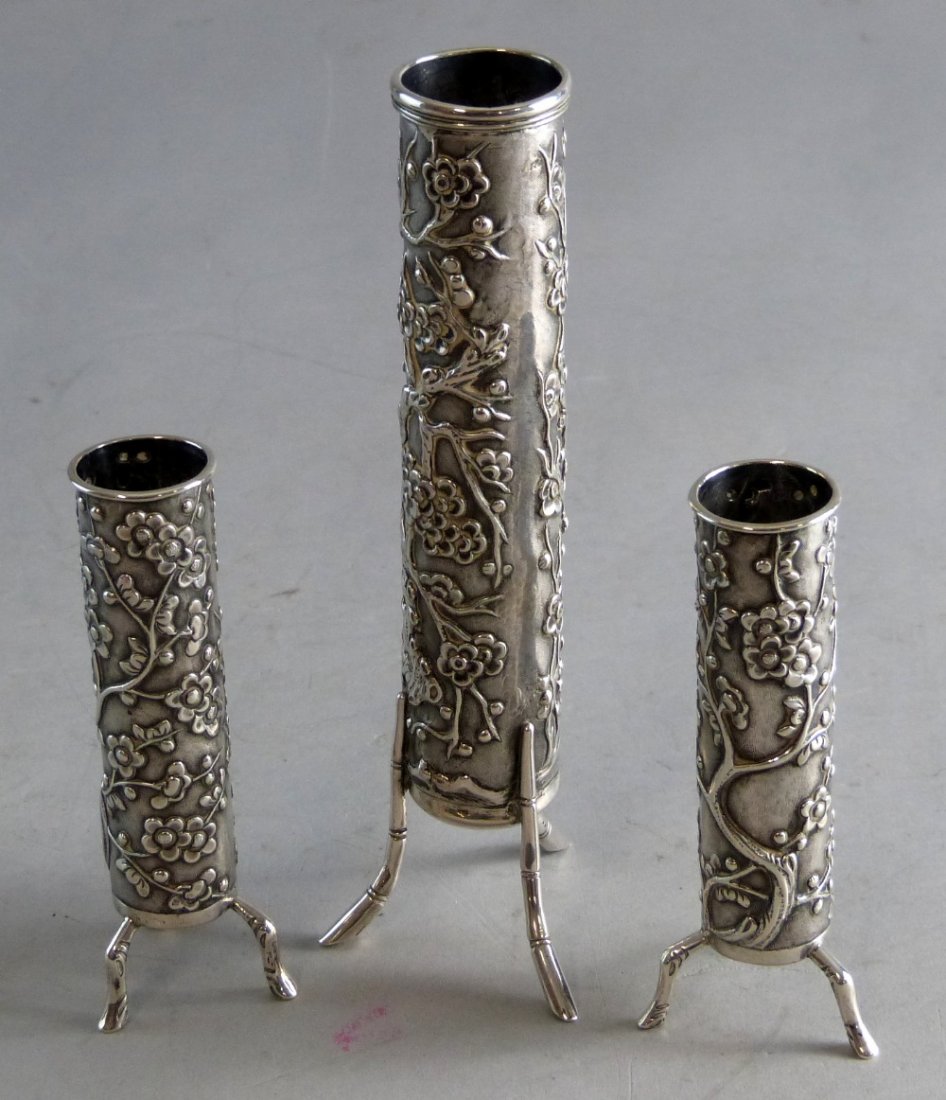 Trio of late 19th/20th century Chinese silver vases: Trio of late 19th/20th century Chinese silver vases with floral decoration, each raised on three stylised bamboo supports, by Wang Hing, tallest vase 7.5" high,