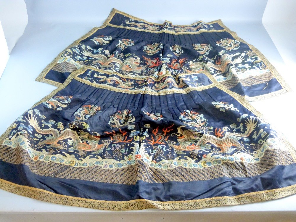 Two 19th century Chinese silk skirt panels, embroidered: Two 19th century Chinese silk skirt panels, embroidered with dragons in couched gilt thread the top section pleated and with wide embroidered band, 71 x 76 cm,