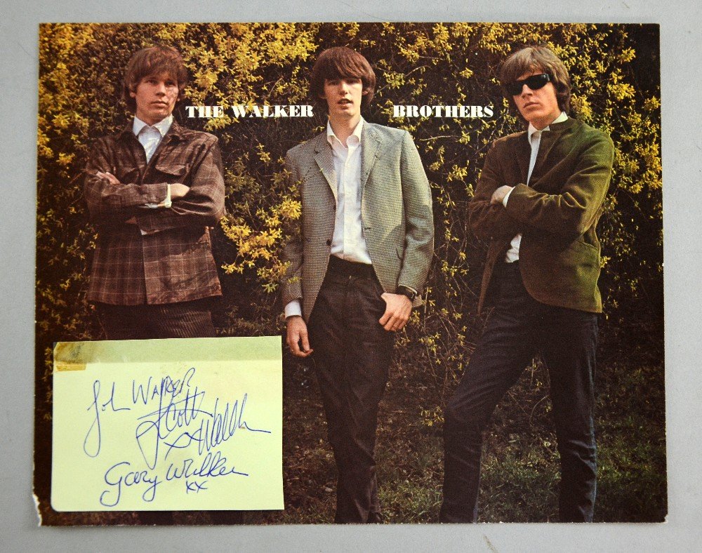 The Walker Brothers, American Pop Group, a signed: The Walker Brothers, American Pop Group, a signed autograph page by John Walker, Scott Walker & Gary Walker, signed in blue biro & a promotional print (2)