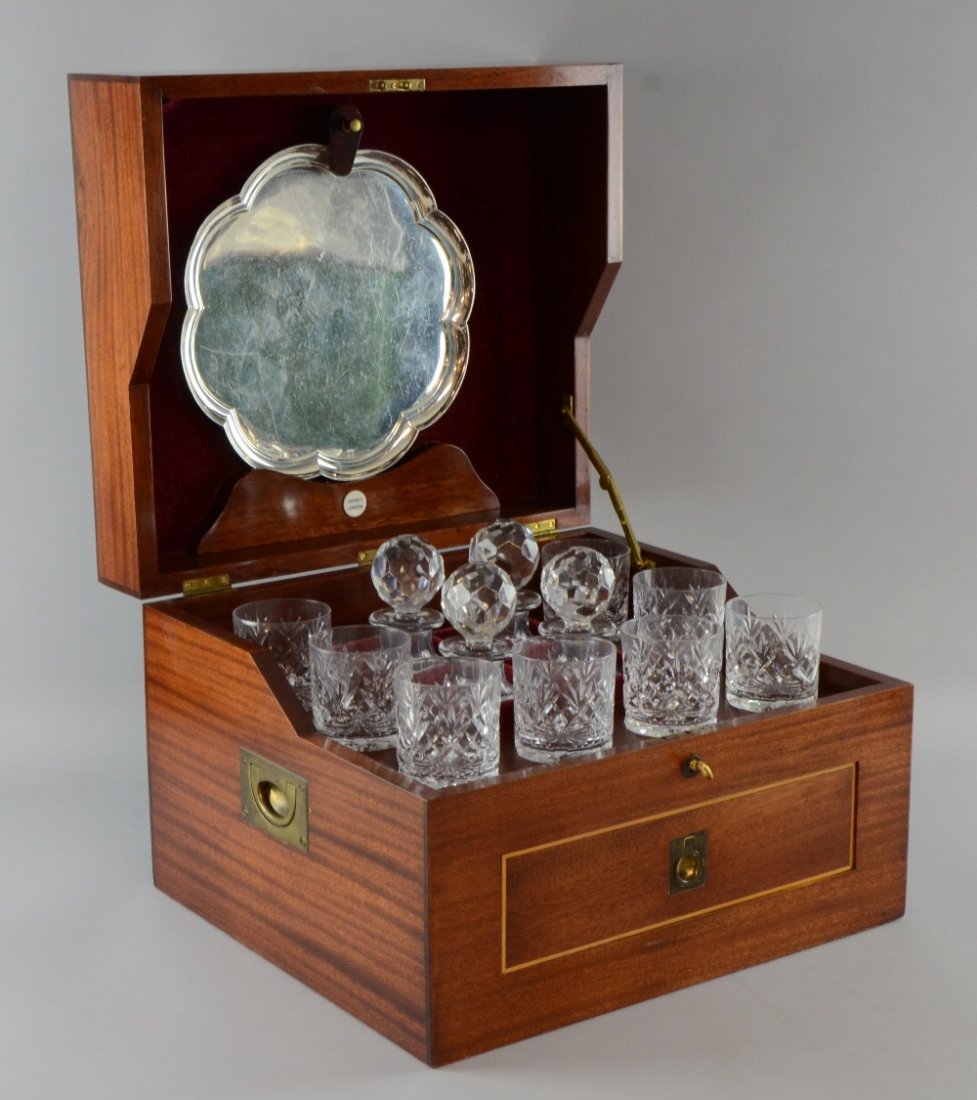 Modern mahogany decanter box the inlaid cover enclosing: Modern mahogany decanter box the inlaid cover enclosing four decanters, eight glasses and a silver tray, over a single drawer containing ice tongs, cigar cutter and bottle opener, 11 x 16 x 14in. (28 