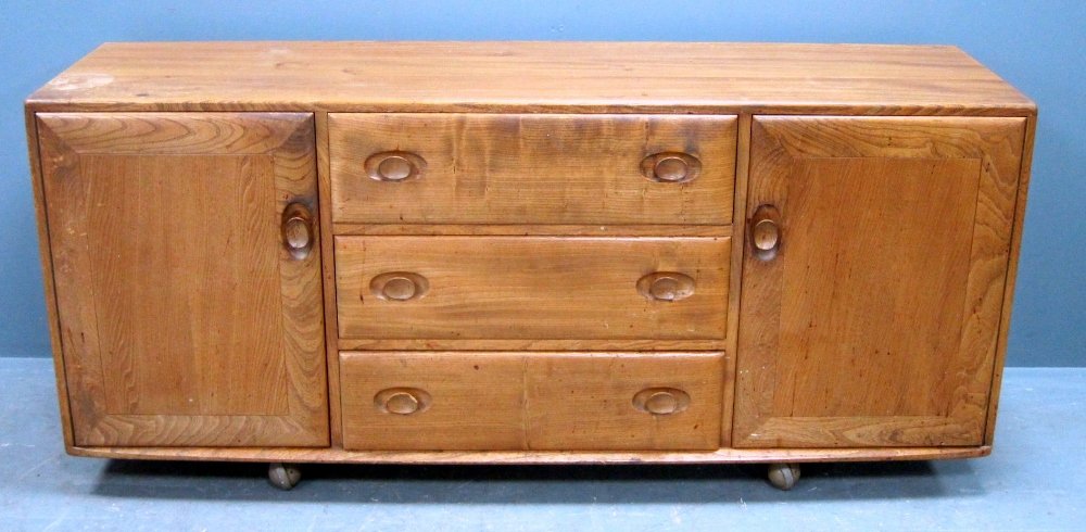 Ercol mid 20th C light elm low sideboard with drawers: Ercol mid 20th C light elm low sideboard with drawers flanked by two cabinets, 155 cm wide